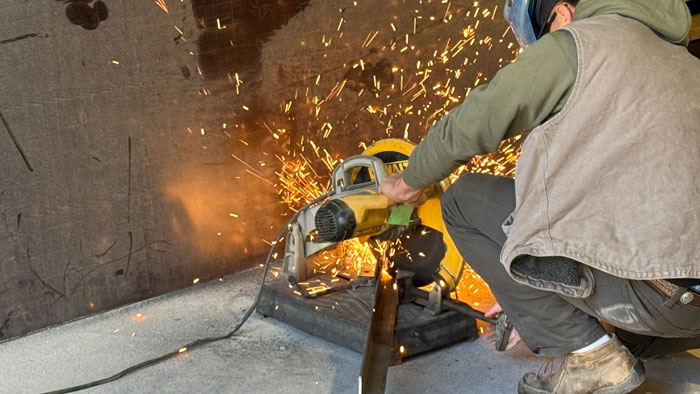 <b>A member of the Keokuk High School's team cuts a piece of the angle iron frame of the shop cart being constructed during the 2024 High School Skills Challenge at Carl A. Nelson & Company. The eighth-annual event tested the skills high school construction trades students are learning in the classroom by applying them to real-world projects.</b> (CANCO)
